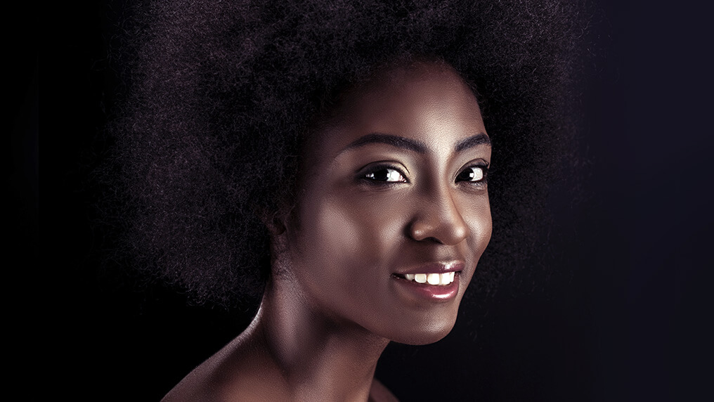 Mulher negra casual cabelo cacheado black power sorrindo olhando para o  horizonte